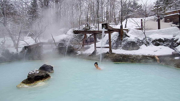 Relaxing winter soak in a snow-covered outdoor hot spring