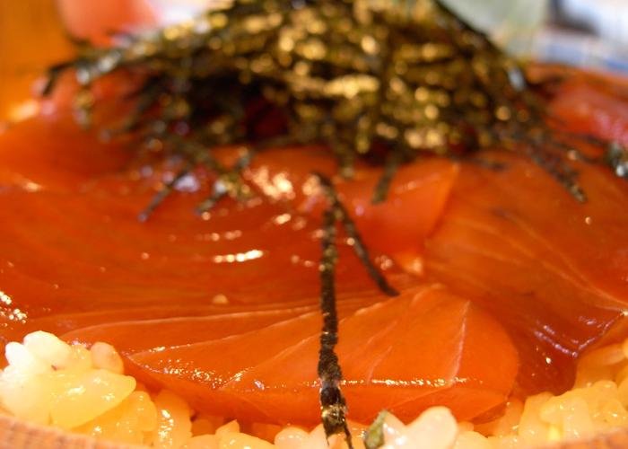 Close-up of rice with red tuna and seaweed shavings on top