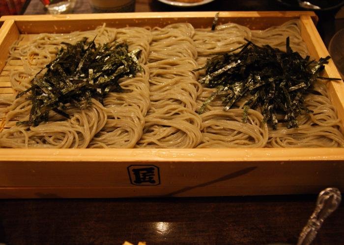 A square platter with bundles of cooked noodles arranged on top