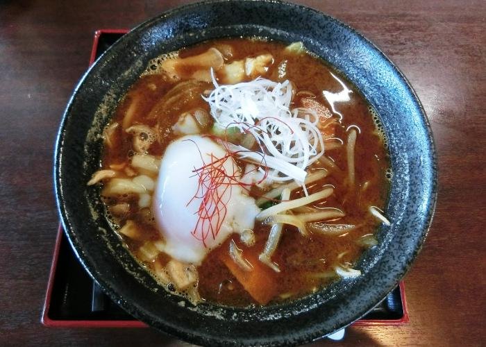 A bowl of kameyama ramen with thick, dark soup broth