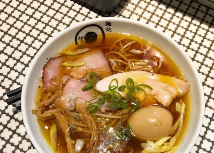 Bowl of Janomeya Ramen in Kyoto featuring a large boiled egg, bamboo shoots, chicken