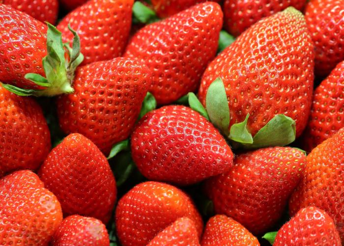 Bright red strawberries with leafy green tops