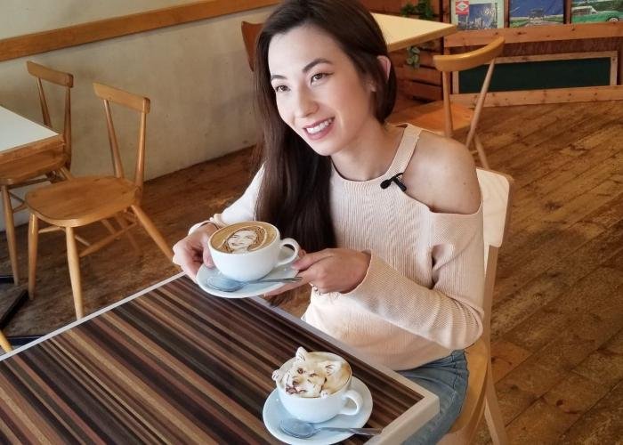 Shizuka Anderson poses with a cup of latte art at Reissue in Shibuya