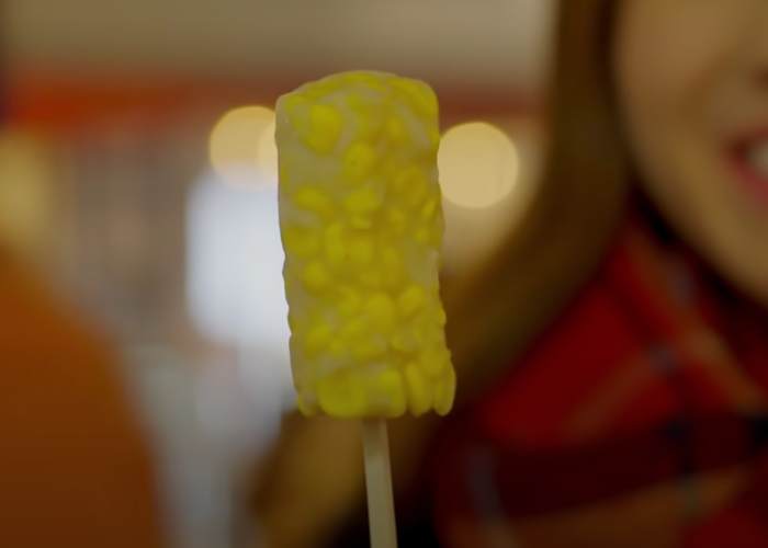 Close up shot of a corn fish cake on a wooden stick