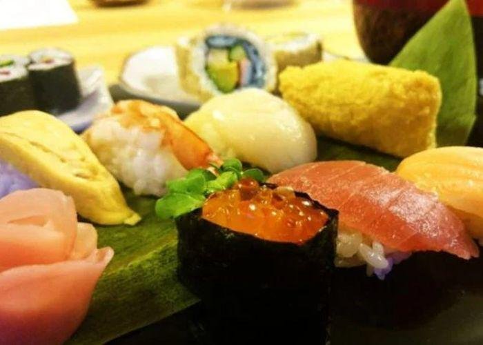 A close up shot of a plate full of different types of sushi