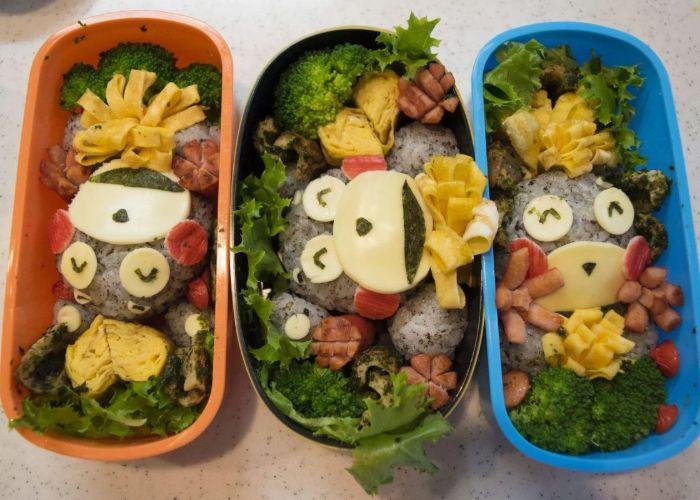 Overhead shot of three character bentos with bearlike characters made from rice, vegetables and other ingredients