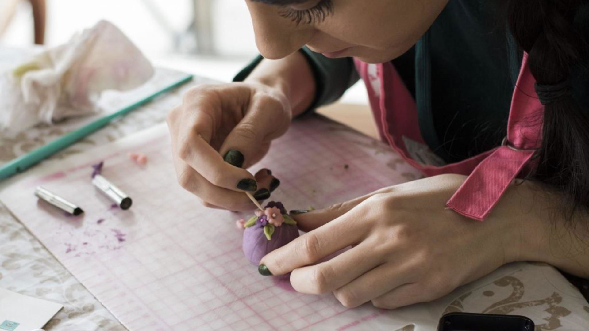 Detailed art creation on small figurine by skilled hands