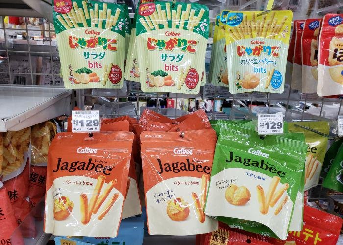 Six small bags of potato stick snacks hanging on convenience store shelves