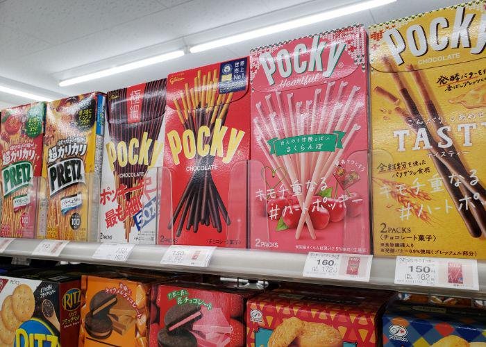Colorful boxes of different flavors of Pocky lined up on convenience store shelf