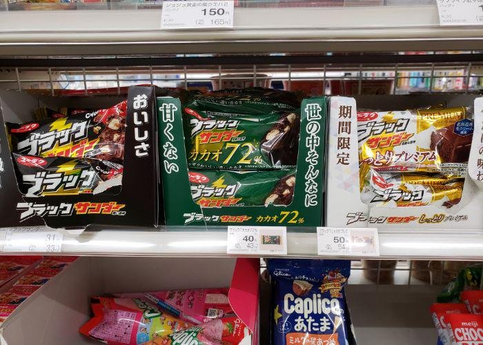 Three small boxes of different varieties of Black Thunder chocolate candy bars on convenience store shelf