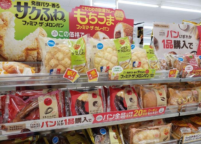 Family Mart shelves filled with different limited time breads, large signs advertising melon pan, curry pan