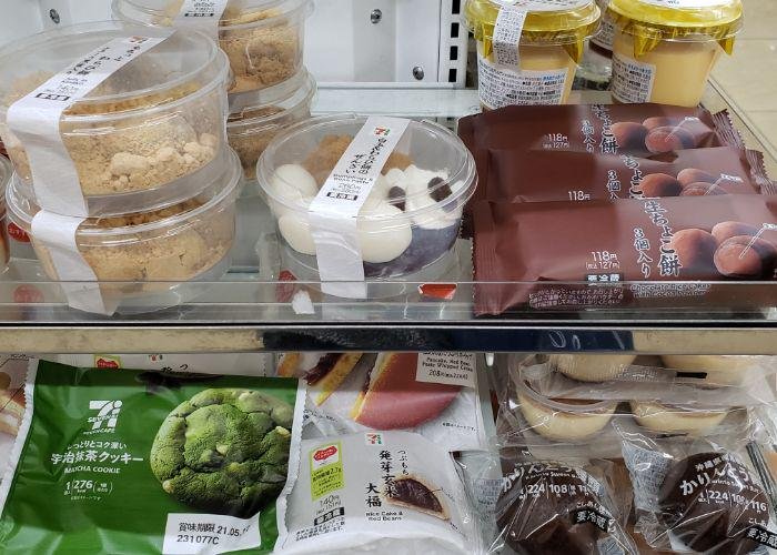 7-eleven refrigerated shelf with traditional Japanese sweets like chocolate mochi, a matcha cookie, red bean rice cake