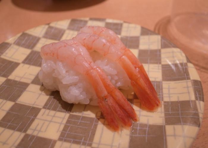 Amaebi (sweet shrimp) nigiri sushi on a checkered plate