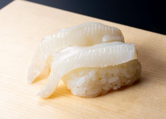 Engawa flounder nigiri sushi on a white wood background