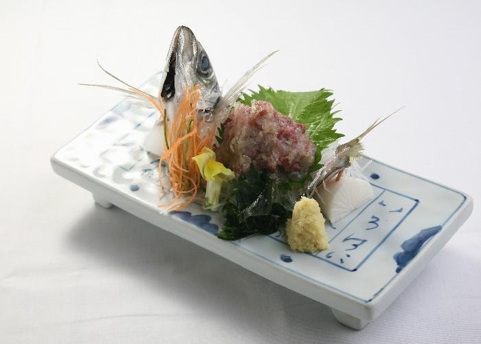 Namerou, minced fish plated on a dish with wasabi, shiso, and a fish head