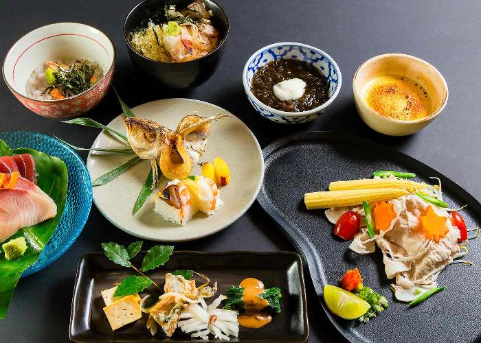 Colorful Japanese kaiseki ryori dishes laid out on a gray table