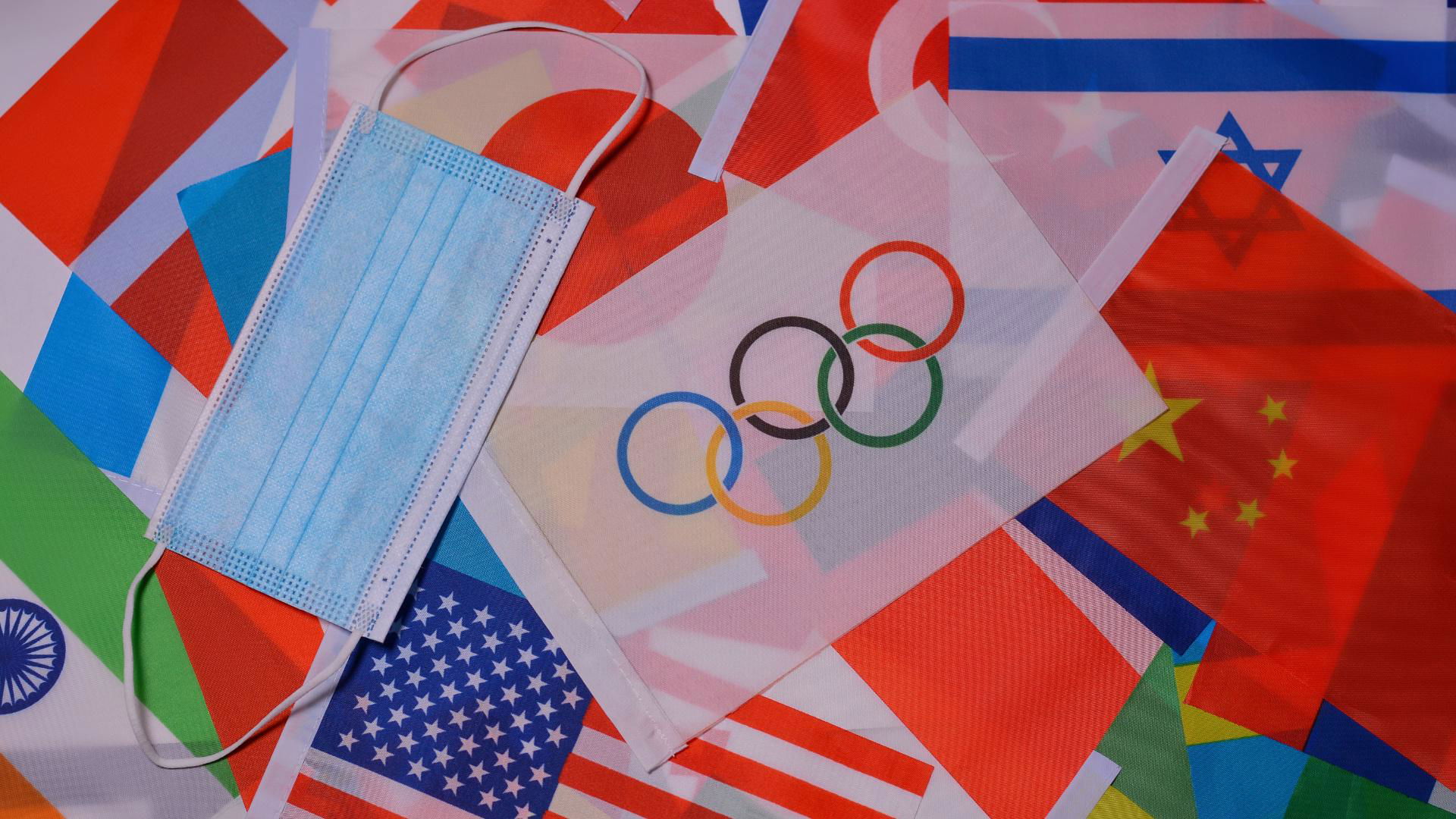 Olympic rings on flags with a mask, symbolizing global unity and health