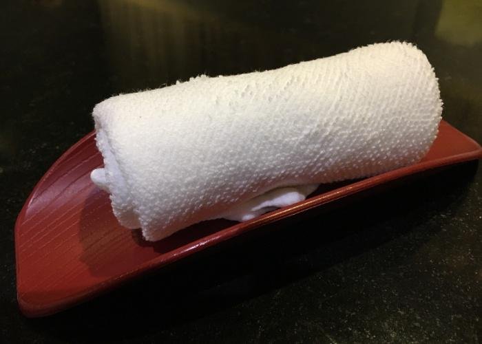 Oshibori, damp white cloth towel that is given at restaurants for guests to wipe their hands