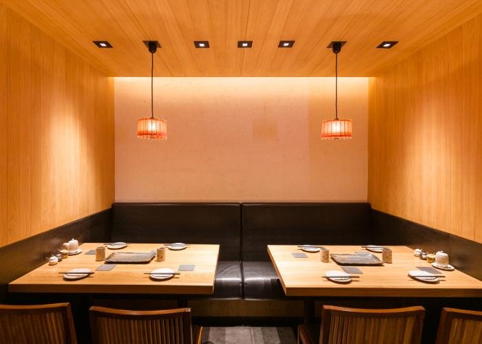 Japanese restaurant interior, a dimly lit private room with two wooden tables
