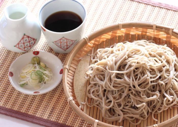 Shinshu Soba, served with cold noodles on a woven plate, and dipping sauce on the side