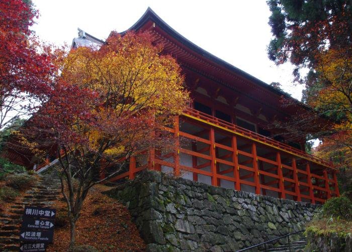 A shot of a red building at Enryakuji Temple, surrounded by autumn trees