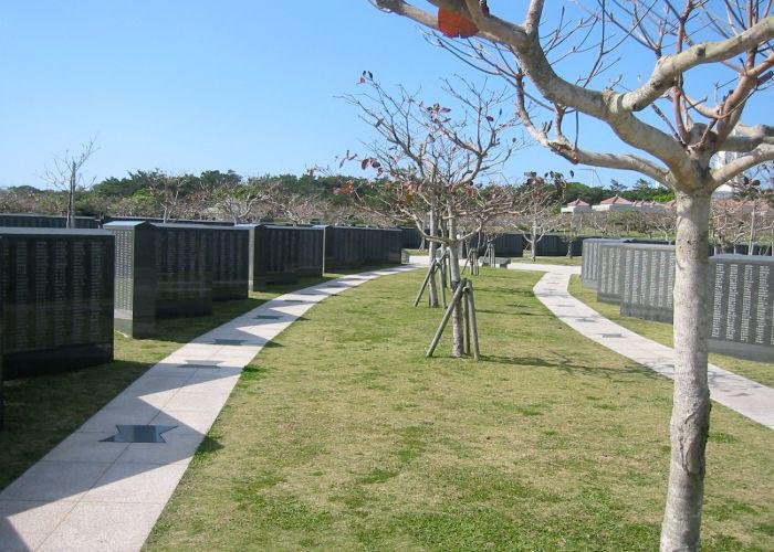 A pathway in the Okinawa Peace Memorial Park lined with stone memorials inscribed with the names of fallen soldiers