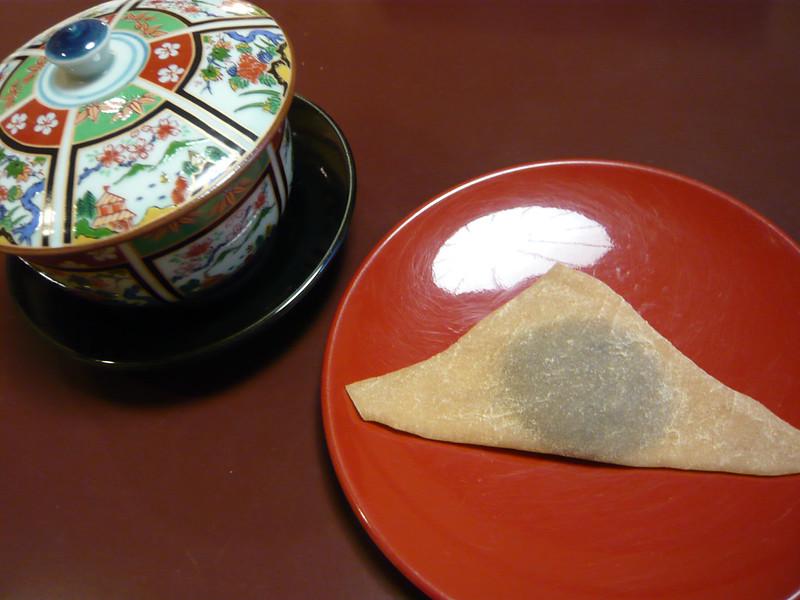 Nama yatsuhashi on a lacquer plate next to Japanese ceramics