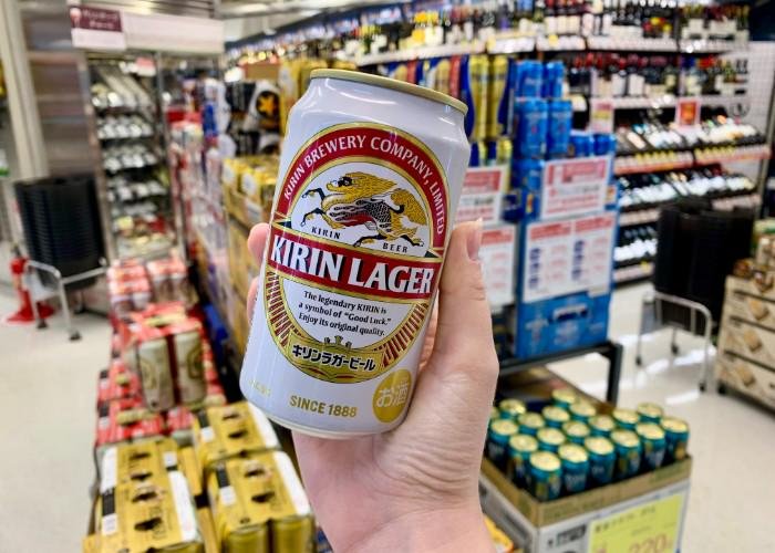 A hand holding a Kirin Lager beer can