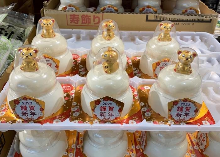 Kagami mochi with small zodiac tiger figures stacked at a store 