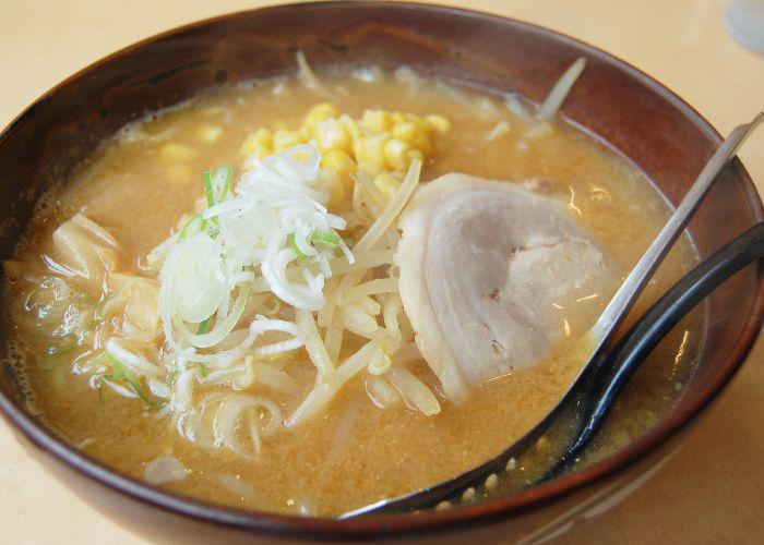 Close up of a bowl of Sapporo ramen with noodles, broth, pork and sweetcorn.