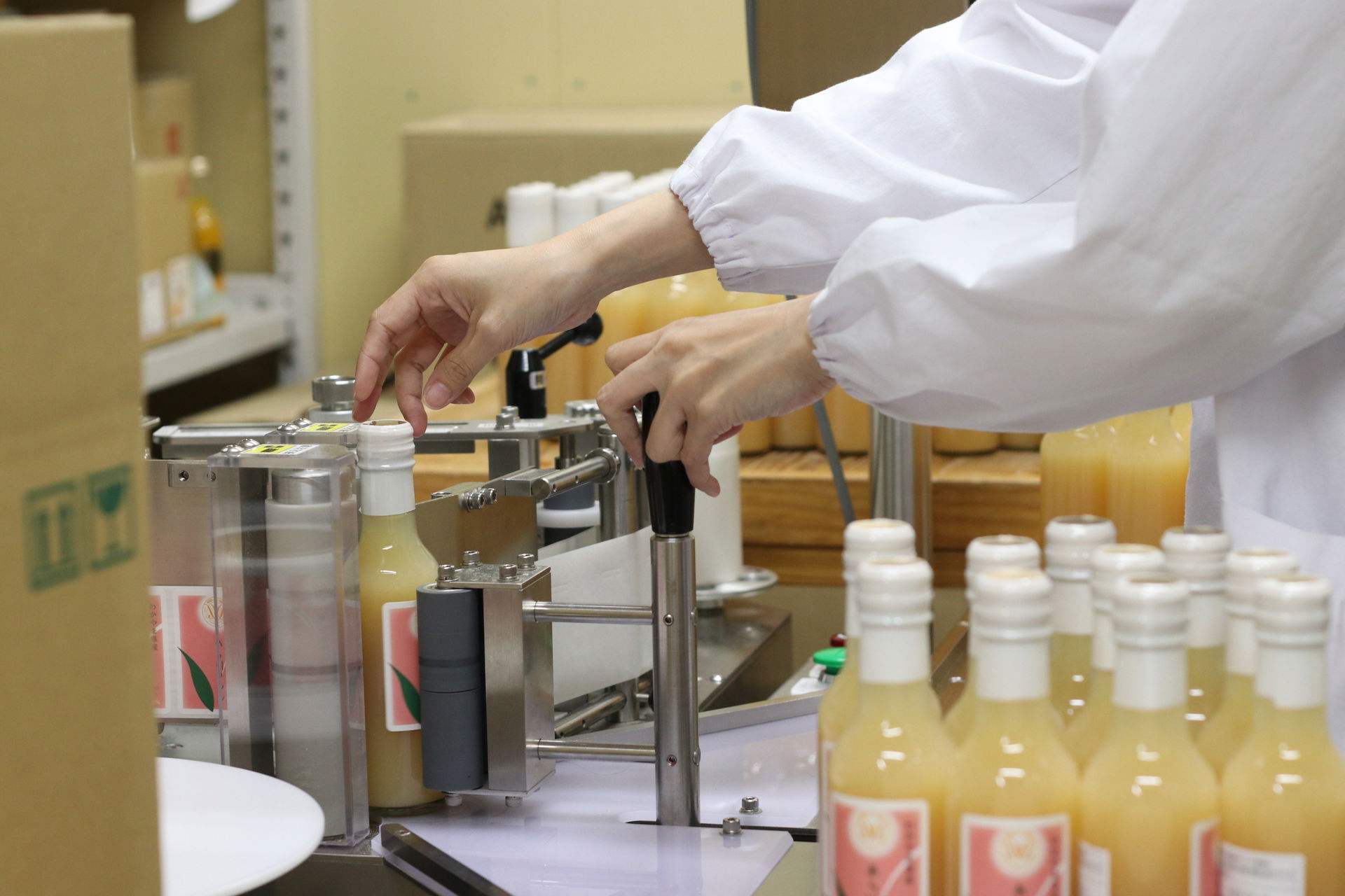 Worker labeling juice bottles in a factory
