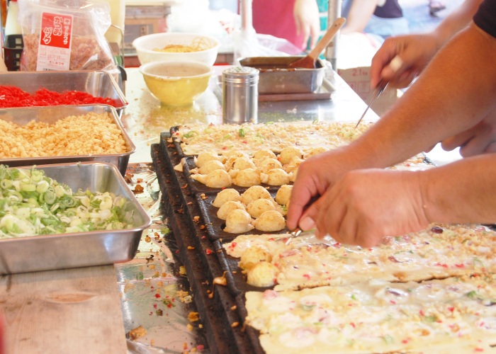 Takoyaki getting made at a street food stall at a festival