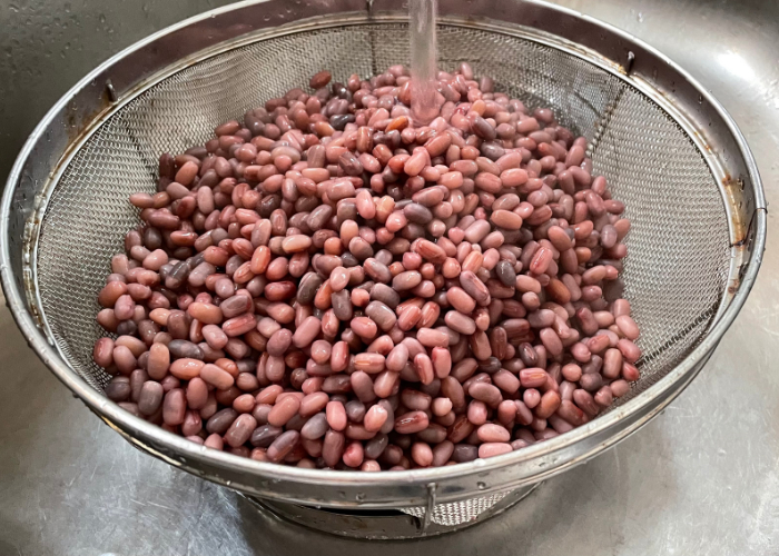 Rinsing red beans in a colander