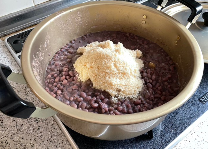 Pot full of cooked red beans and sugar