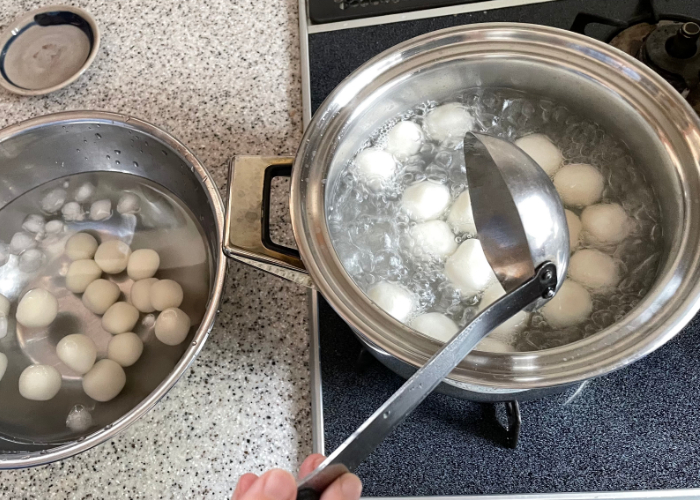 Boiling shiratama dango in a pot next to an ice bath