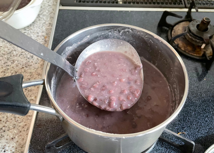 Ladle full of sweet red bean soup in a pot