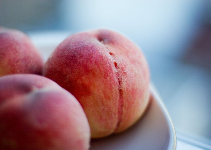 A close-up of three Japanese white peaches