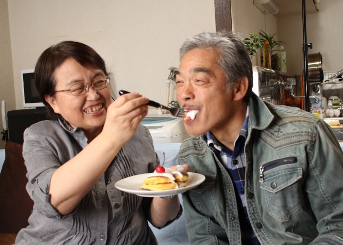 Japanese couple with the wife feeding the husband some cake