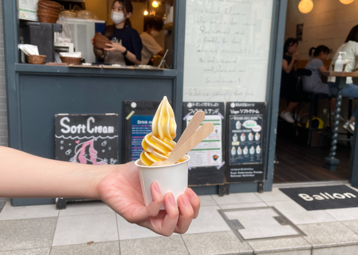 Hand holding out a cup of vegan soft serve from Ballon in Nakameguro