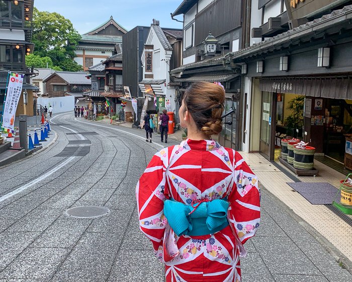 Women in yukata looks down an old Japanese street in Narita, Japan
