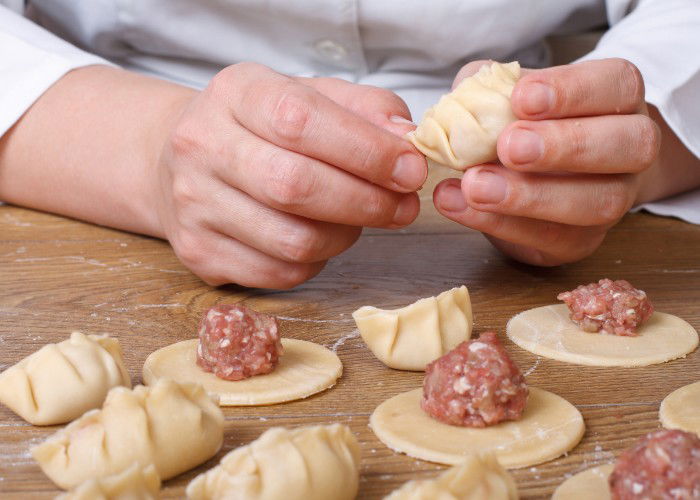 Hands making gyoza