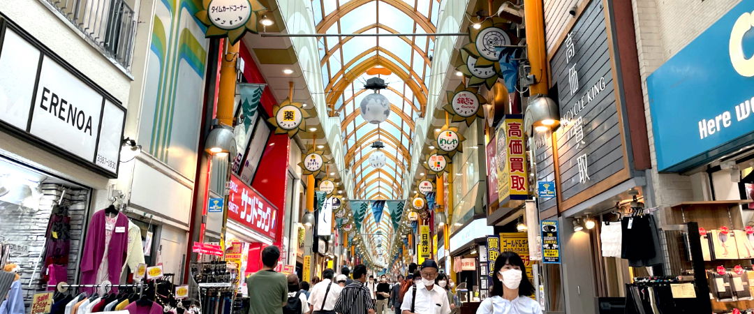Bustling Japanese shopping arcade with vibrant storefronts and crowd