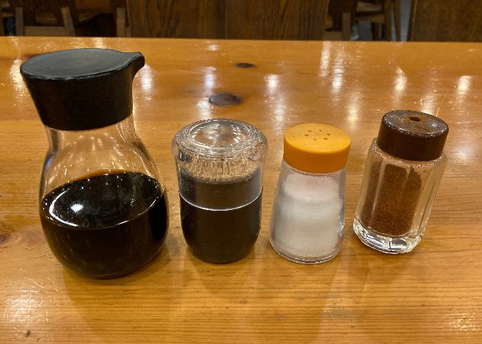 A bottle of Japanese soy sauce next to other condiments