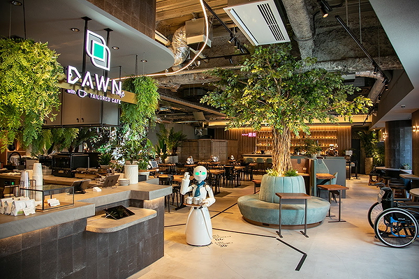 Modern robot servers at a lush cafe with greenery