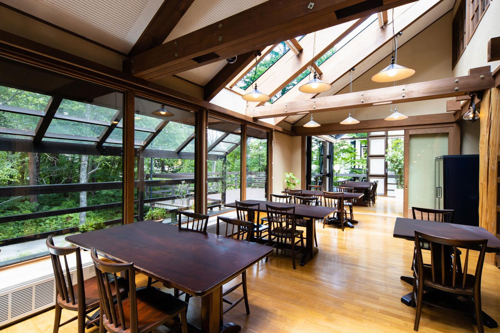 Bright restaurant interior with wooden tables and large windows