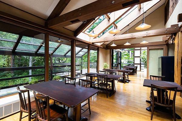 Bright restaurant interior with wooden tables and large windows
