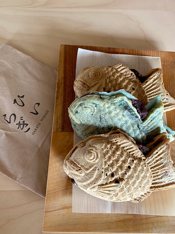 Delicious taiyaki pastries filled with red bean on a wooden plate