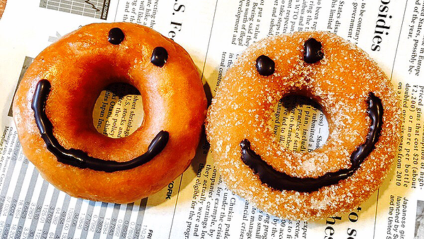 Smiley face donuts on a newspaper background