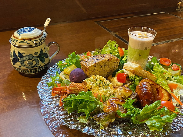 Gourmet platter with assorted dishes and herbal tea at a cozy restaurant.