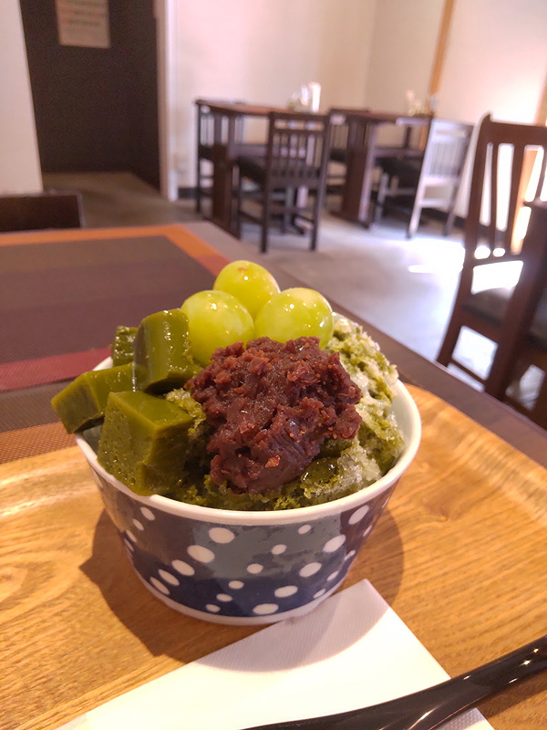 Matcha dessert bowl with red bean topping in cozy restaurant